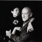 A man and a woman hugging while smiling at the camera.