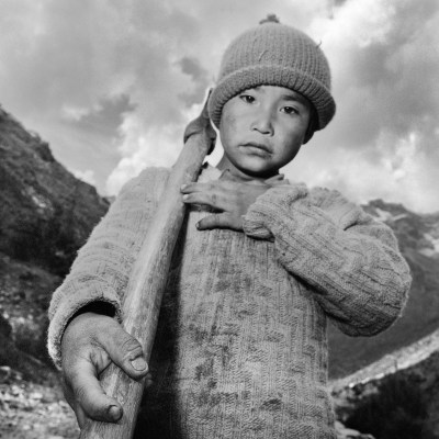 A child with an axe waving on one shoulder.