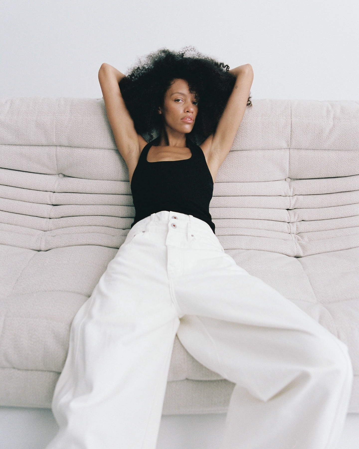 Images may contain clothes pants, adult sofa furniture face cushions and home decoration
