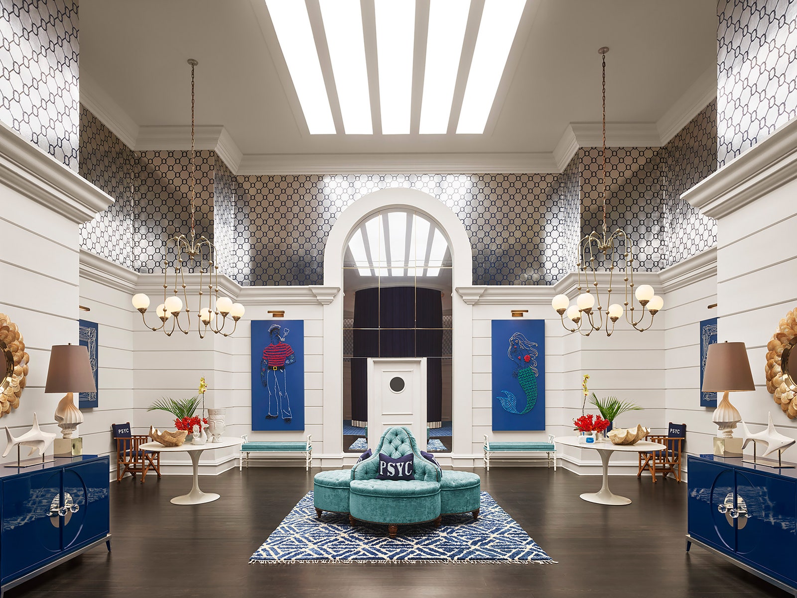 Image may contain lamps home decoration carpet chair furniture table building foyer indoors and people