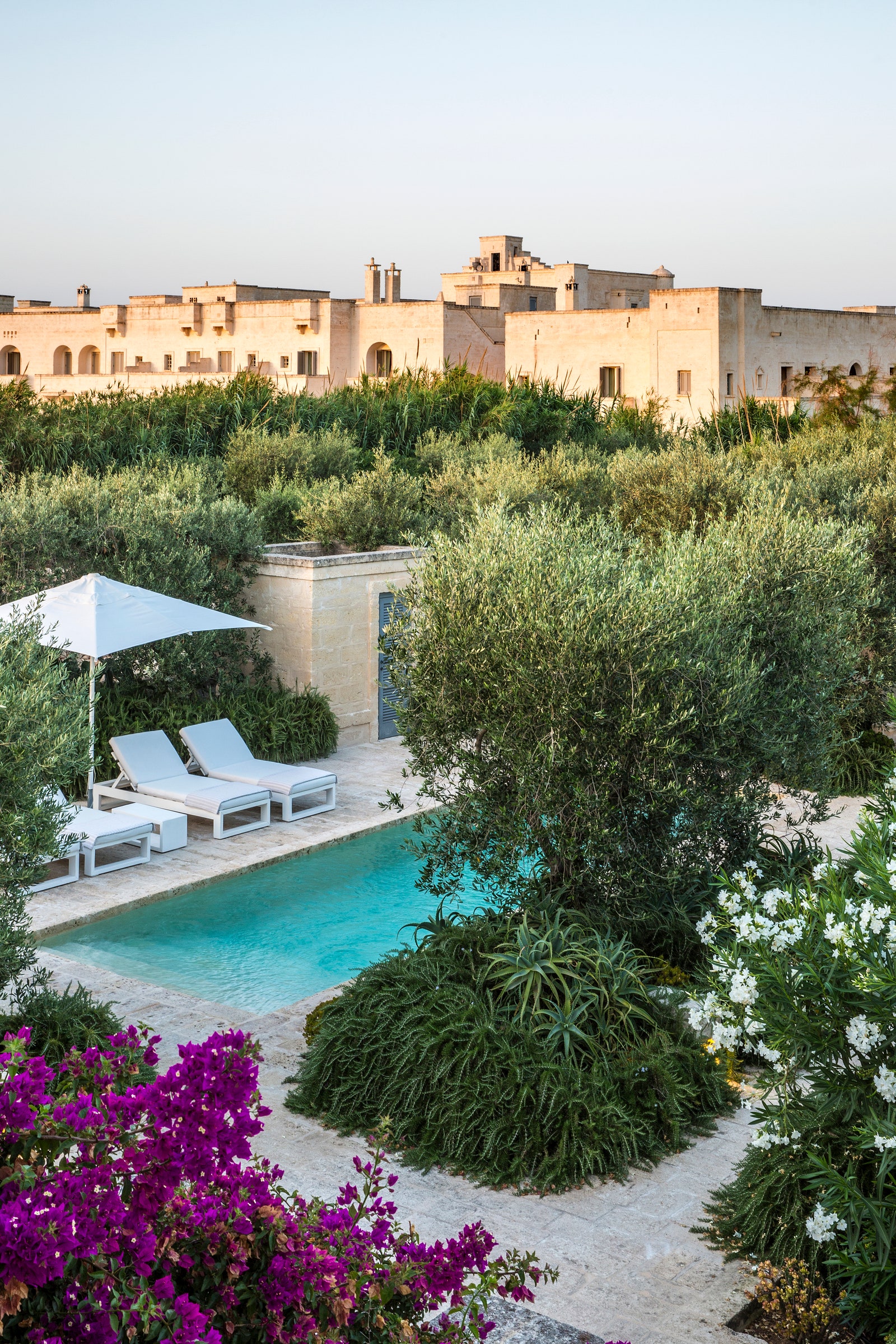 Images may contain architectural houses houses houses pool water chairs furniture pool and backyard