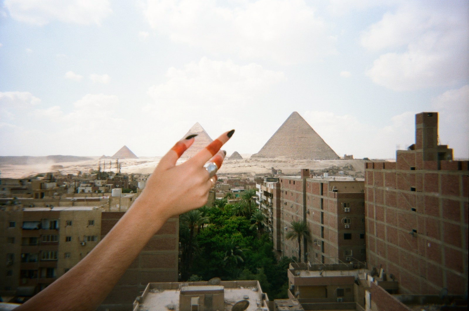 Images may contain urban neighborhood adult city accessories jewelry rings and metropolis