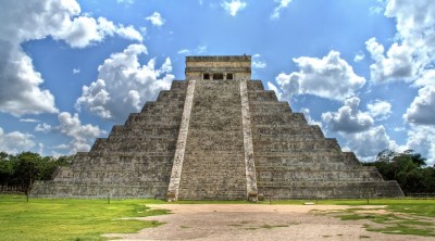 The Kukulkan pyramid in Chichen Itza is one of the tourist attractions in the area. Green vegetation and blue sky in this vibrant place