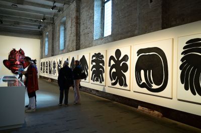 Several people walked on a drawing lined with abstract people, and they sprouted multiple arms, seemingly bent.