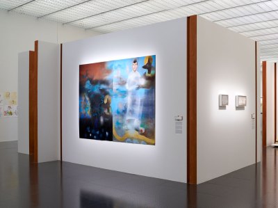 The installation landscape of the museum exhibition displays a painting with men from Anubis and Osiris. 