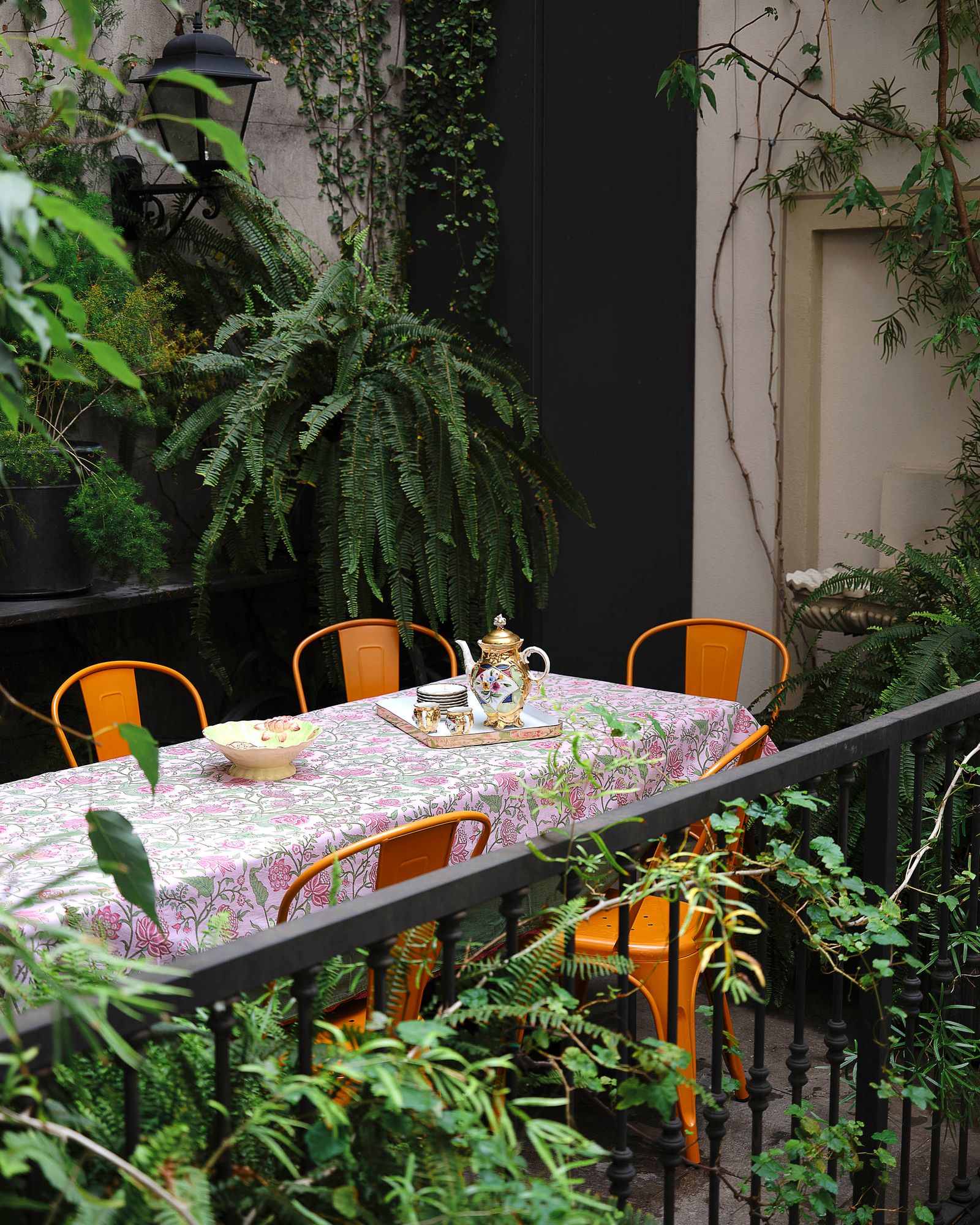 Images may contain architectural balcony architectural furniture table table chair dining table plant cup and light