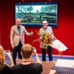 A man receives flowers in front of a restored Van Gogh painting.