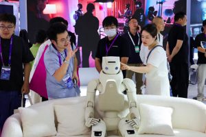 People interact with humanoid robots at Fourier booth at the World Artificial Intelligence Conference in Shanghai, China.