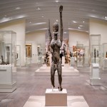 A person's sculptures are before many other display cabinets.