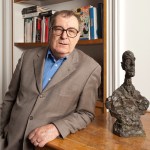 Daniel Lelong is placed next to the sculpture of Alberto Giacometti.