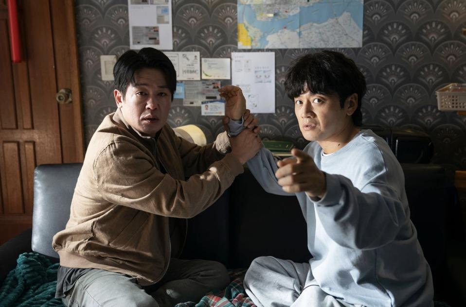 The detective holds the informant's arm.