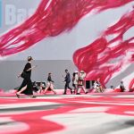 BASEL, SWITZERLAND - JUNE 17: Visitors walk past an artwork of Katharina Grosse "CHOIR" 2025 displayed at Art Basel at Messe Basel on June 17, 2025 in Basel, Switzerland.  (Photo by Harold Cunningham/Getty Images)
