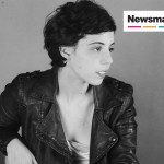 A black and white photo of a woman wearing a leather jacket and short hair.