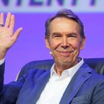 Jeff Koons smiled as he raised his right hand. He sat, wearing a white dress, shirt and blazer. He is the stage at the 2024 OMR Music Festival held in Hamburg, Germany on May 8, 2024. Photos Tristar Media/Getty Images