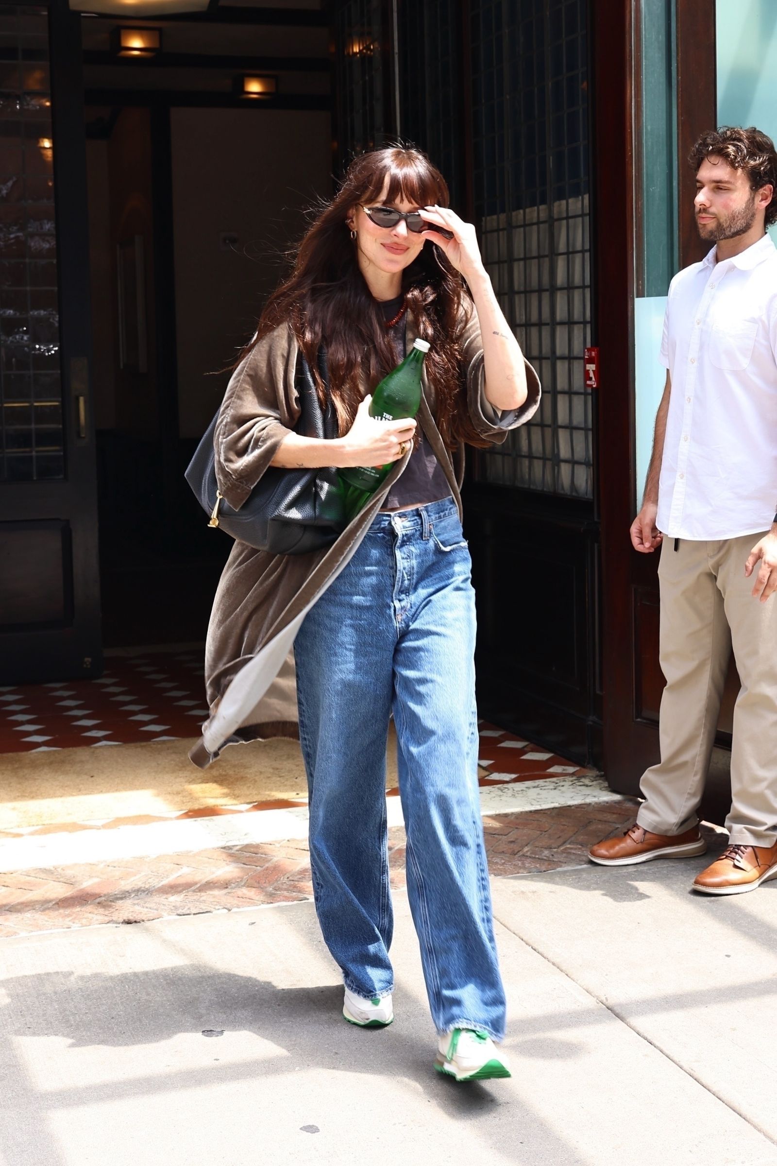 Images may contain Dakota Johnson clothing pants jeans shoes shoes teen adult accessories bag and handbag
