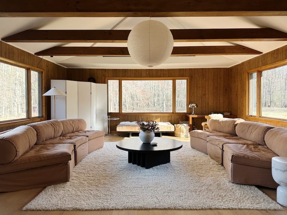 Images may contain home decor interior design lamp coffee table furniture table sofa carpet and architecture