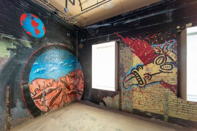 A mural with Earth Earth, a portal showing the corpse of a cow, and a cow with its tongue sticking out.
