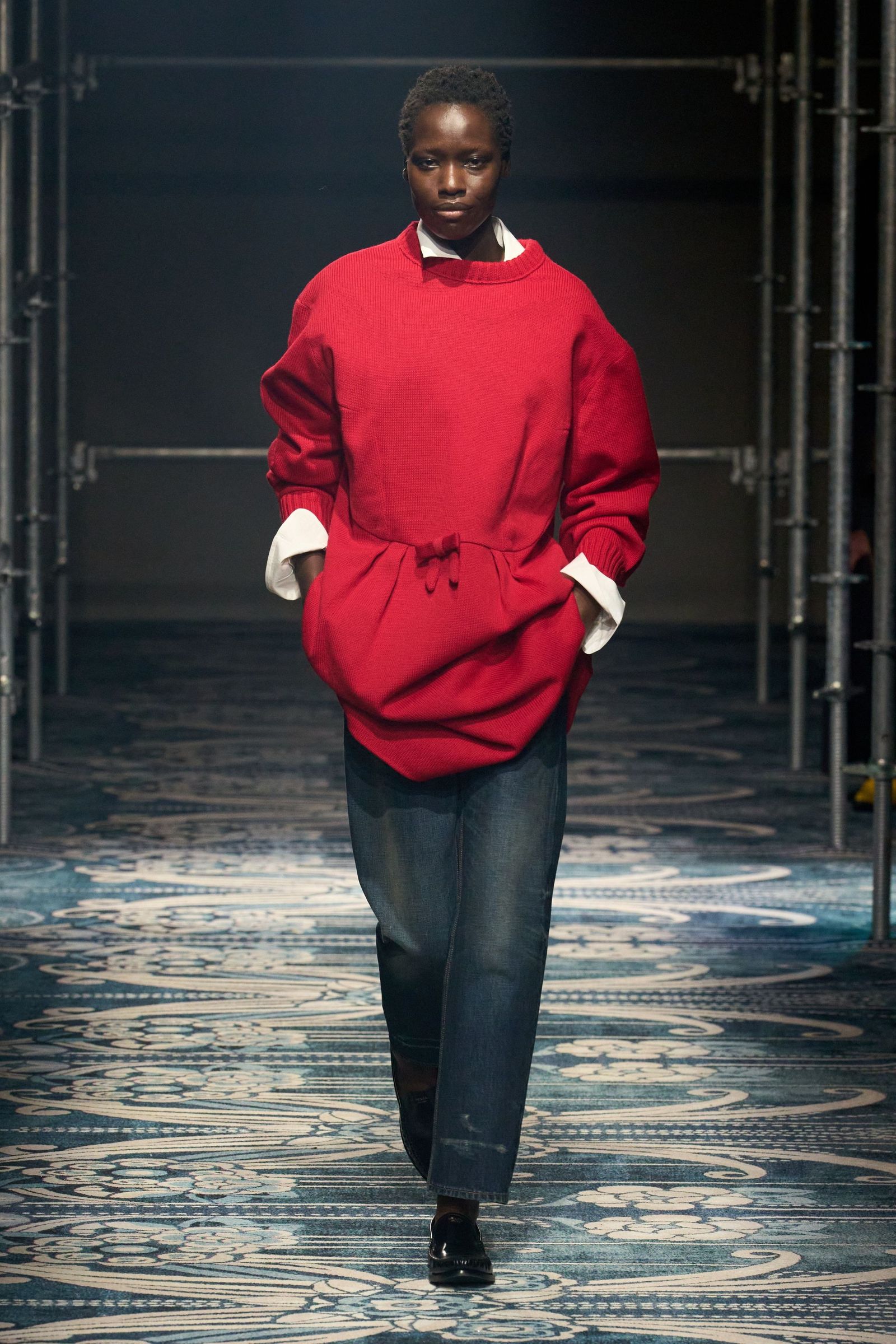Image may contain adult clothing, pants, shoes and gloves standing by a person