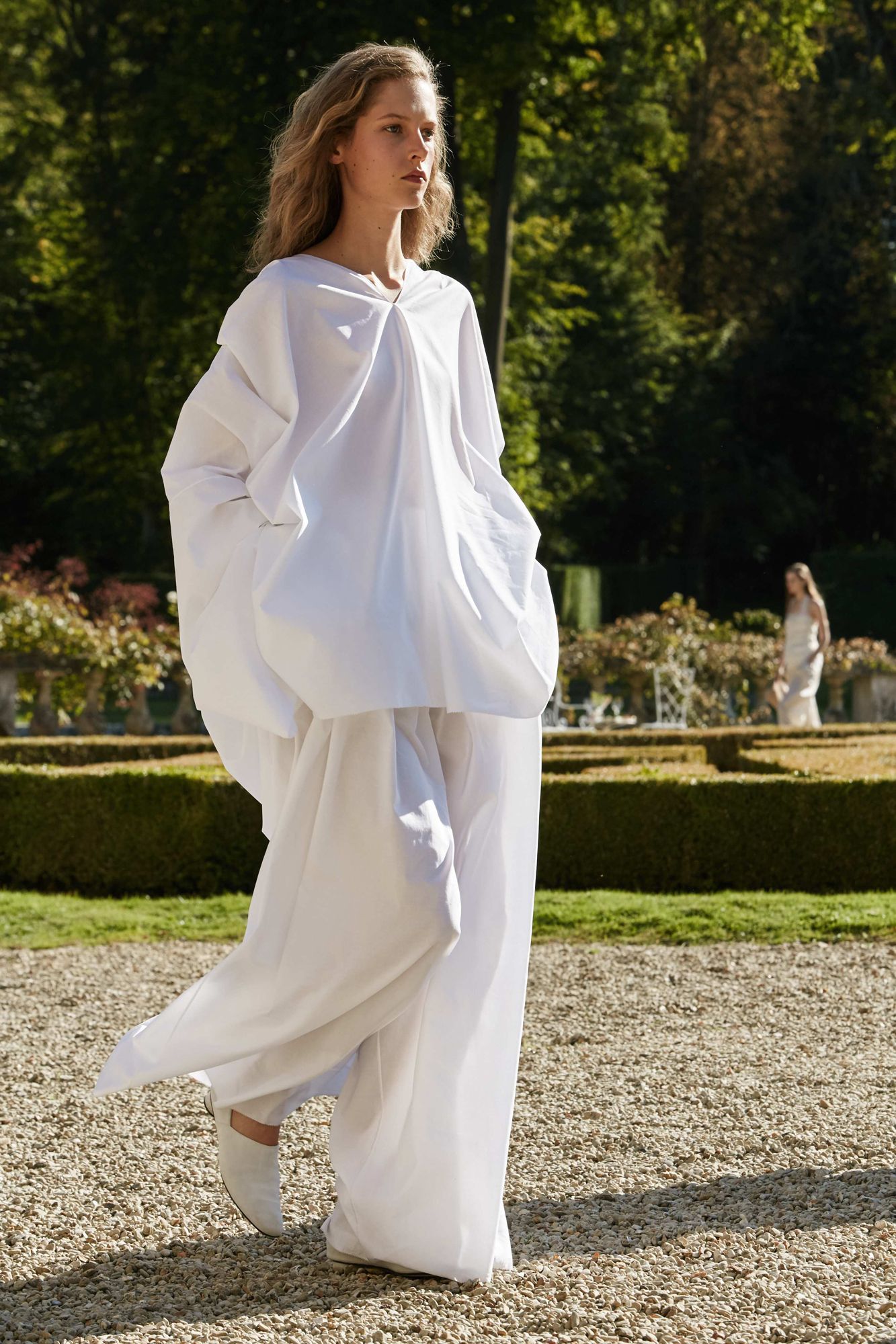 This image may contain clothing, clothing, human fashion robe, long sleeves, plant grass and evening dress