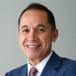 A man in a suit smiling.