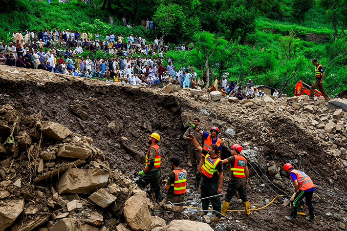 Residents gathered in a storm as rescuers searched for victims, causing heavy rain and flooding