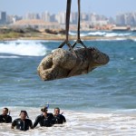 Topshot - Divers Watch When the crane pulls workpieces from the waters of Abu Qir Bay in Alexandria on August 21, 2025, it is part of an activity organized by the Ministry of Tourism and Antiquities to restore sunken antiquities. (Photo taken by Khaled Desouki/AFP) (Photo taken by Khaled Desouki/AFP via Getty Images)