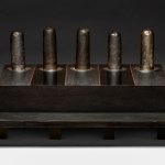 Sculpture made of ceramics, wood, formica, steel. A platform rises from a platform.