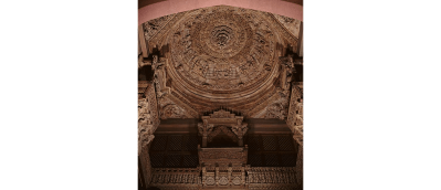 An ornate ceiling in a darkened room.
