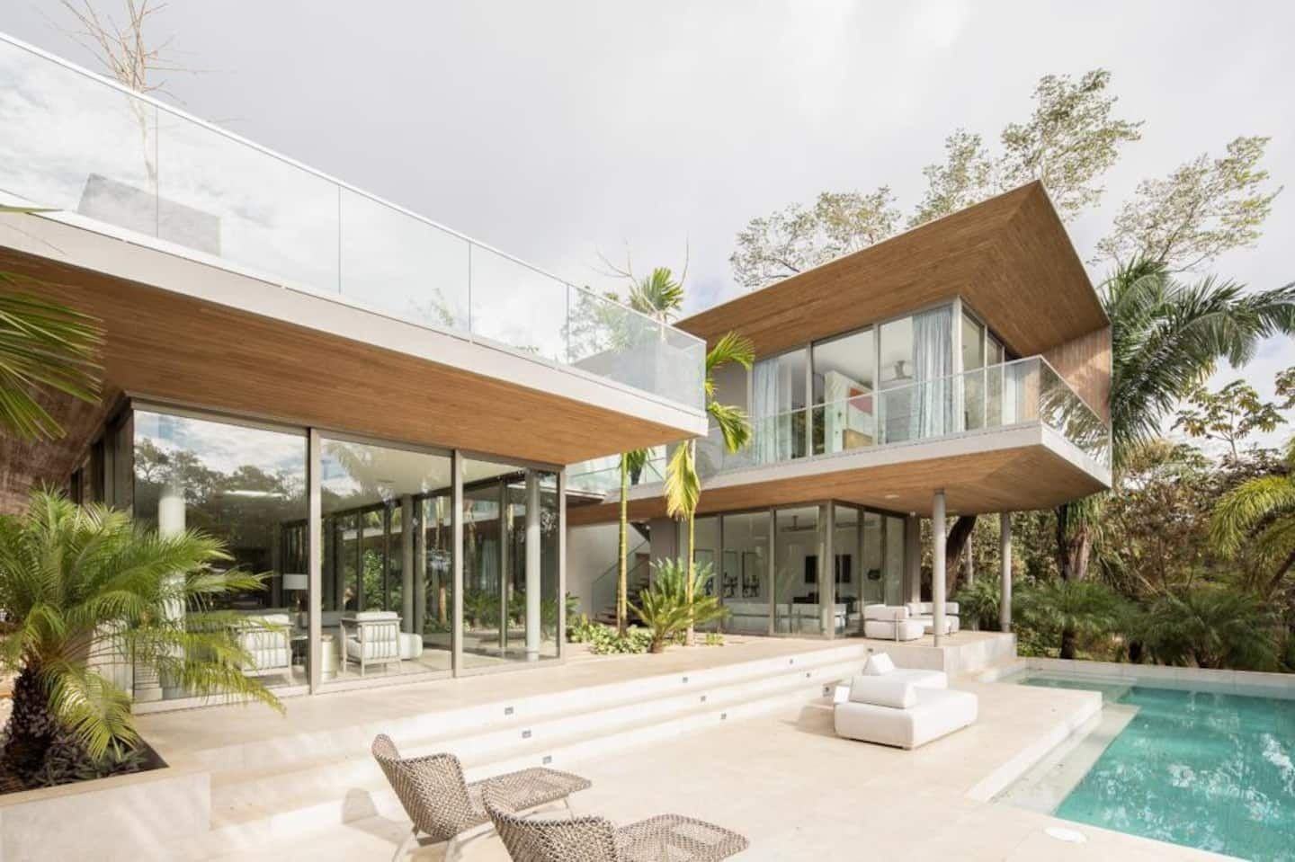 Images may contain architectural houses, housing, interior interior design, pool water chairs and furniture