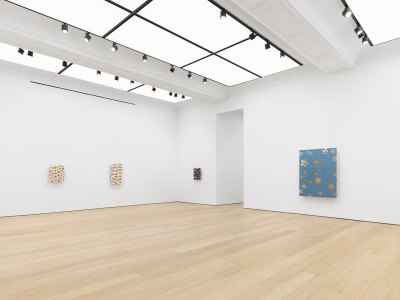 The landscape of the gallery exhibition, with several paintings hanging on the wall. 