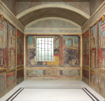 A room with aged paintings of city landscapes on its walls.
