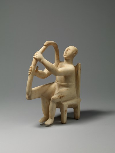 A sculpture of a man seated in a chair and playing a harp.