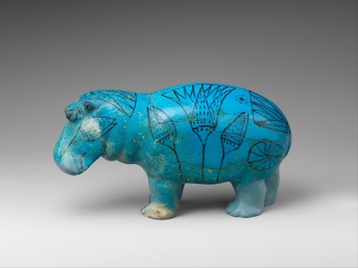 A sculpture of a hippo whose skin is painted blue. Painted onto it are images of lotus flowers.