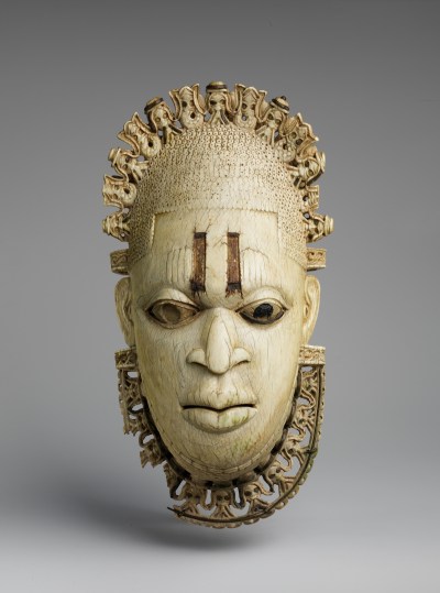 A mask showing a woman's face with mudfish lining her head.