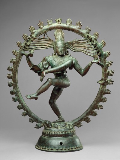 A sculpture of a dancing woman with twirling hair and multiple arms. Surrounding her is a ring of fire.