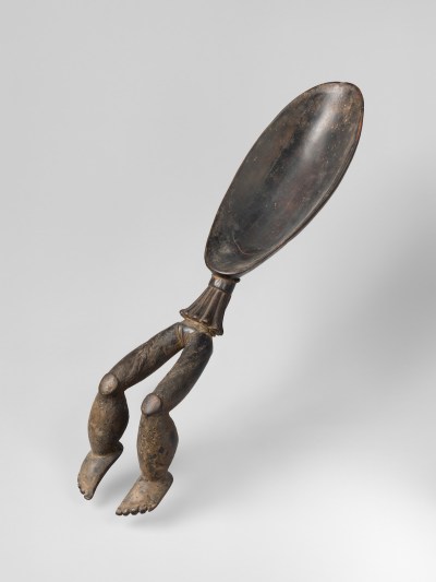A wooden spoon with sculpted legs extending from its curved area.