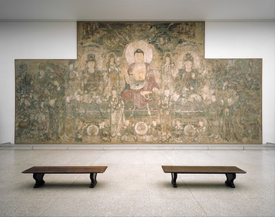 A mural depicting the Buddha surrounded various people in halos.