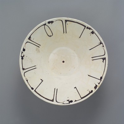 A white bowl with stylized calligraphy running around its border.
