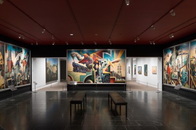 A group of paintings showing speeding trains, blimps, and other industrial matter.