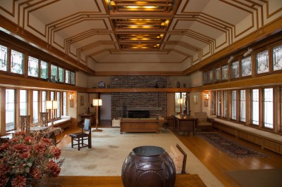 A sparse living room with a chair and lamps in it.