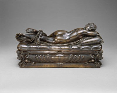 A sculpture of a sleeping, nude person reclining on a mattress and turning over, twirling a sheet in their feet.