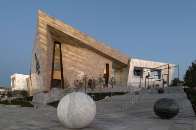 The view of the museum's exterior, with a longer outdoor staircase, is installed with various marble spheres. 