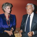 A woman in a blue shirt and a man in a suit.