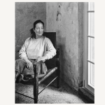 Portrait of a woman sitting on a chair and looking out the window.