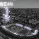 A computer displays an image of fireworks above a stadium.