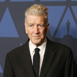 A man in a suit on a red carpet.