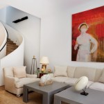 Modern living room with white sofa and grey coffee table. On the wall is a large red paint painting, a nurse wearing a mask.