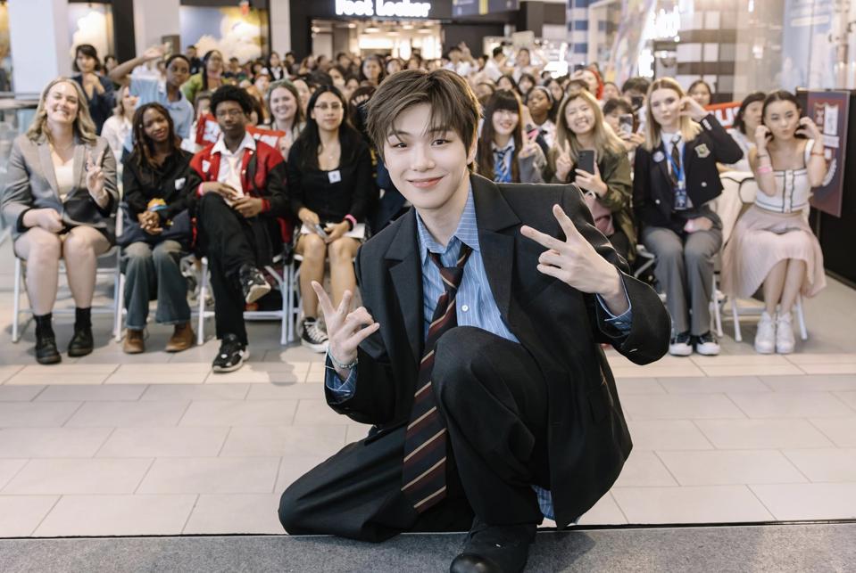 Kang Daniel poses with fans and makes V logos with both hands.