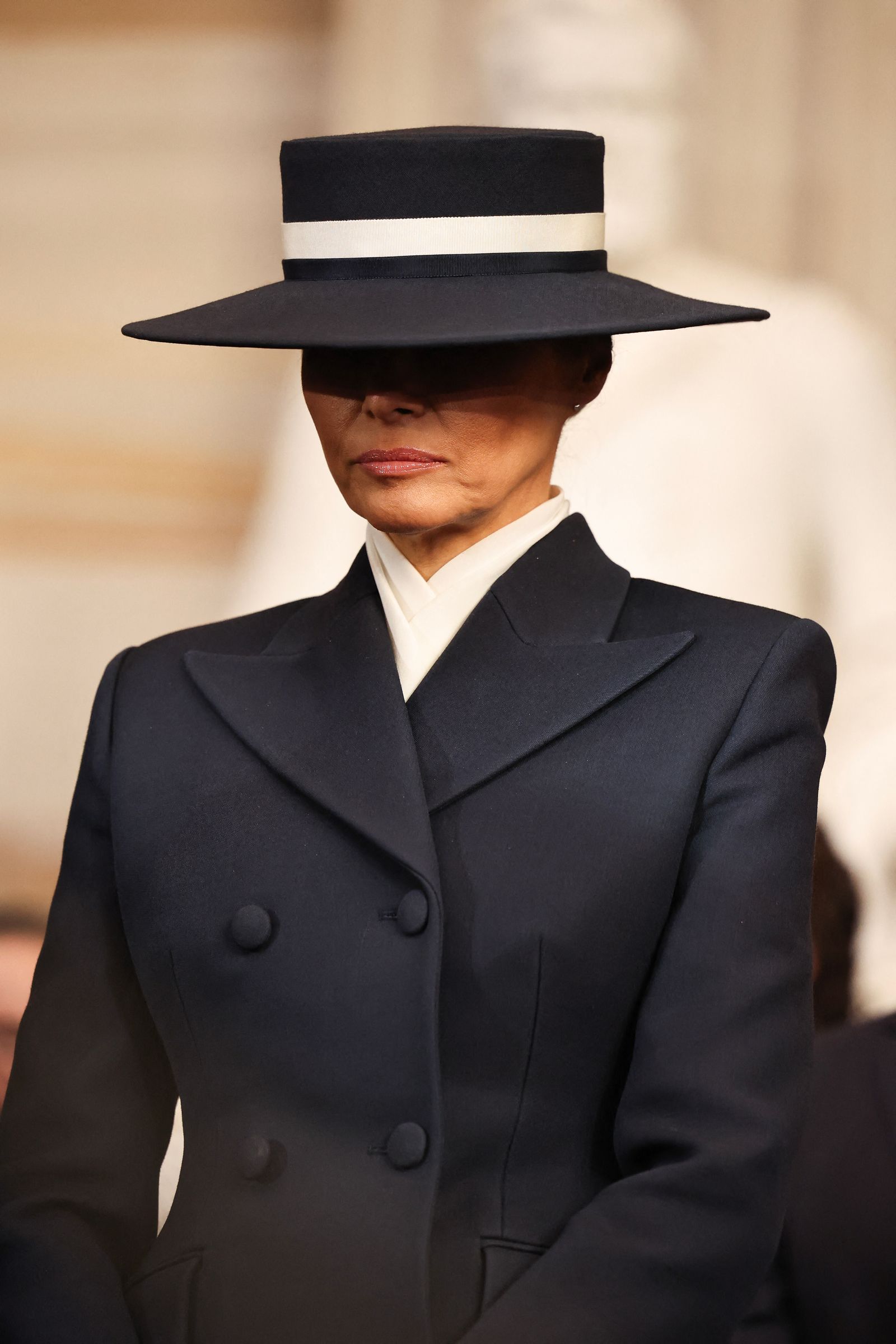 Images may contain Melania Trump outfit formally wearing hat hat man coat face photography and portrait