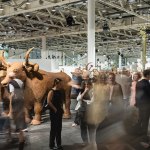 The crowd rotates in front long exposure photos of various artworks.